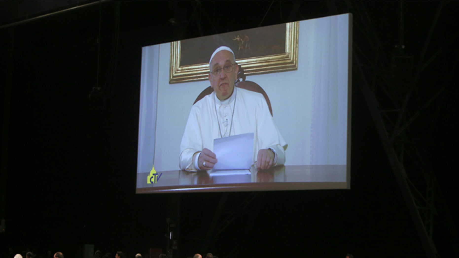 Pope Francis is seen on a giant screen during his video address to a session of 500 experts drafting the so-called Milan Charter that seeks commitments from governments, organizations and individuals during the Expo 2015 world's fair to resolve such issues as food security, decreasing food waste and ensuring biodiversity. in Milan, Italy, Friday, Feb. 7, 2015. Pope Francis emphasized the right to food as fundamental saying the paradox of abundance described by Pope John Paul II -- whereby there is food for everyone yet not everyone can eat -- continues to be an issue.(AP Photo/Antonio Calanni)