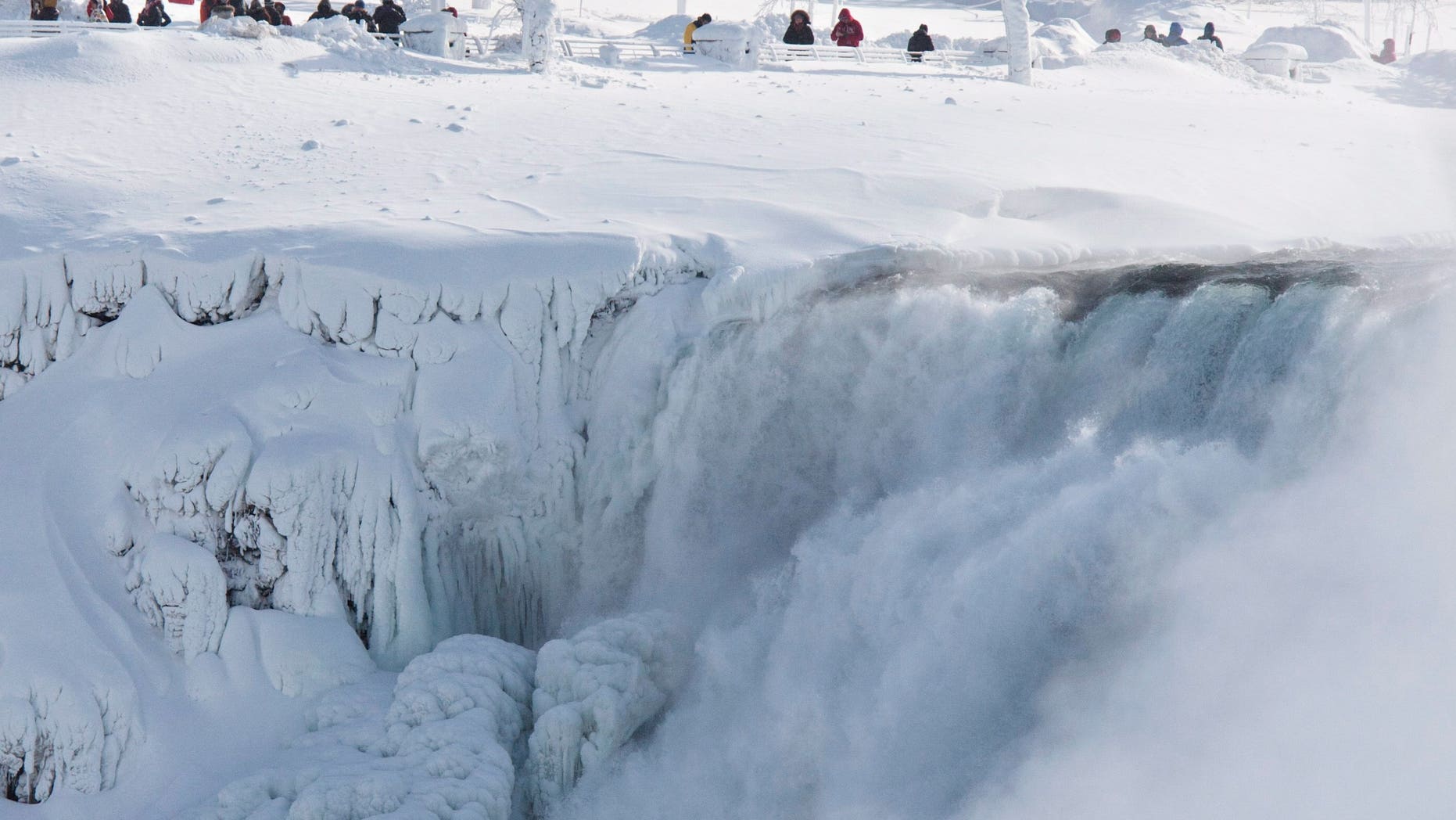 Niagara Falls State Park visitors look over masses of ice formed around the American Falls, photographed from across the Niagara River in Niagara Falls, Ontario, Canada, Thursday, Feb. 19, 2015. (AP Photo/The Canadian Press,Aaron Lynett)