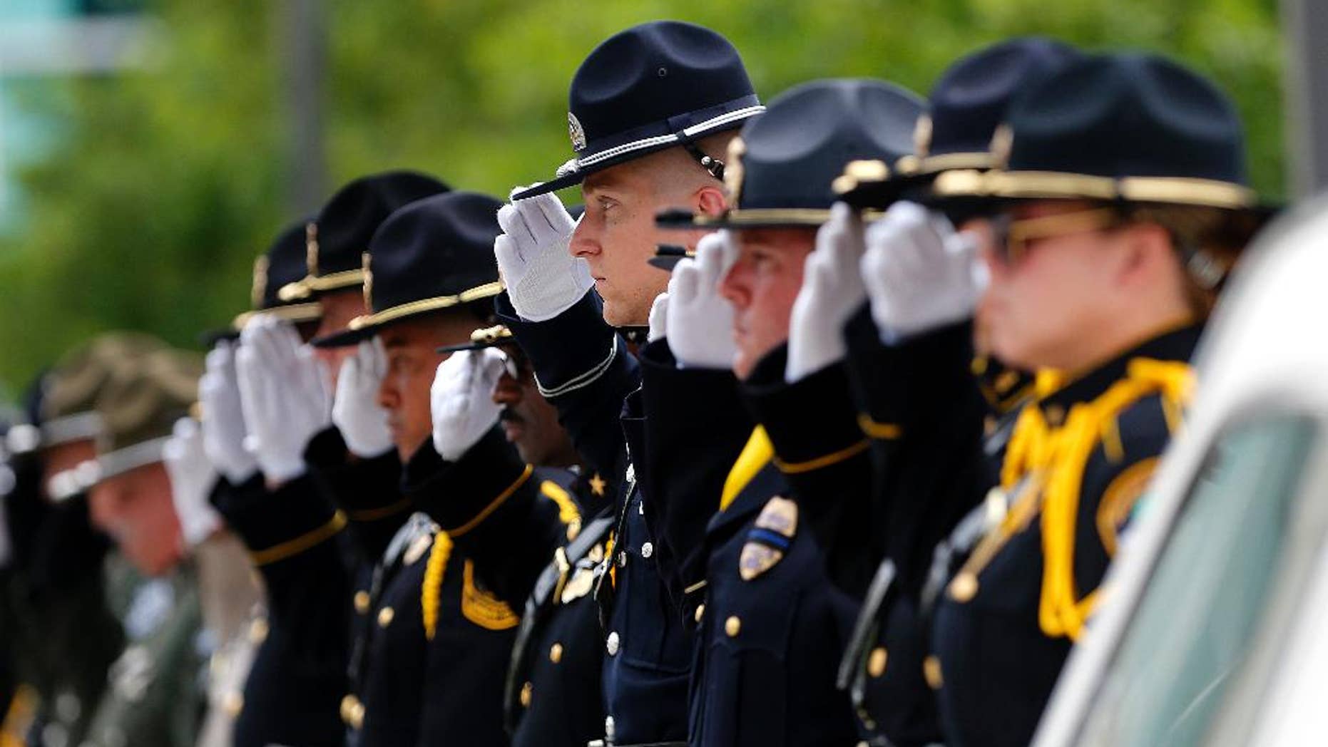 Members of a police honor guard raise their hands in salute as the casket of Baton Rouge police officer Matthew Gerald exits the Healing Place Church after funeral services in Baton Rouge, La., Friday, July 22, 2016. Multiple police officers were killed and wounded Sunday morning in a shooting near a gas station in Baton Rouge, less than two weeks after a black man was shot and killed by police here, sparking nightly protests across the city. (AP Photo/Gerald Herbert)