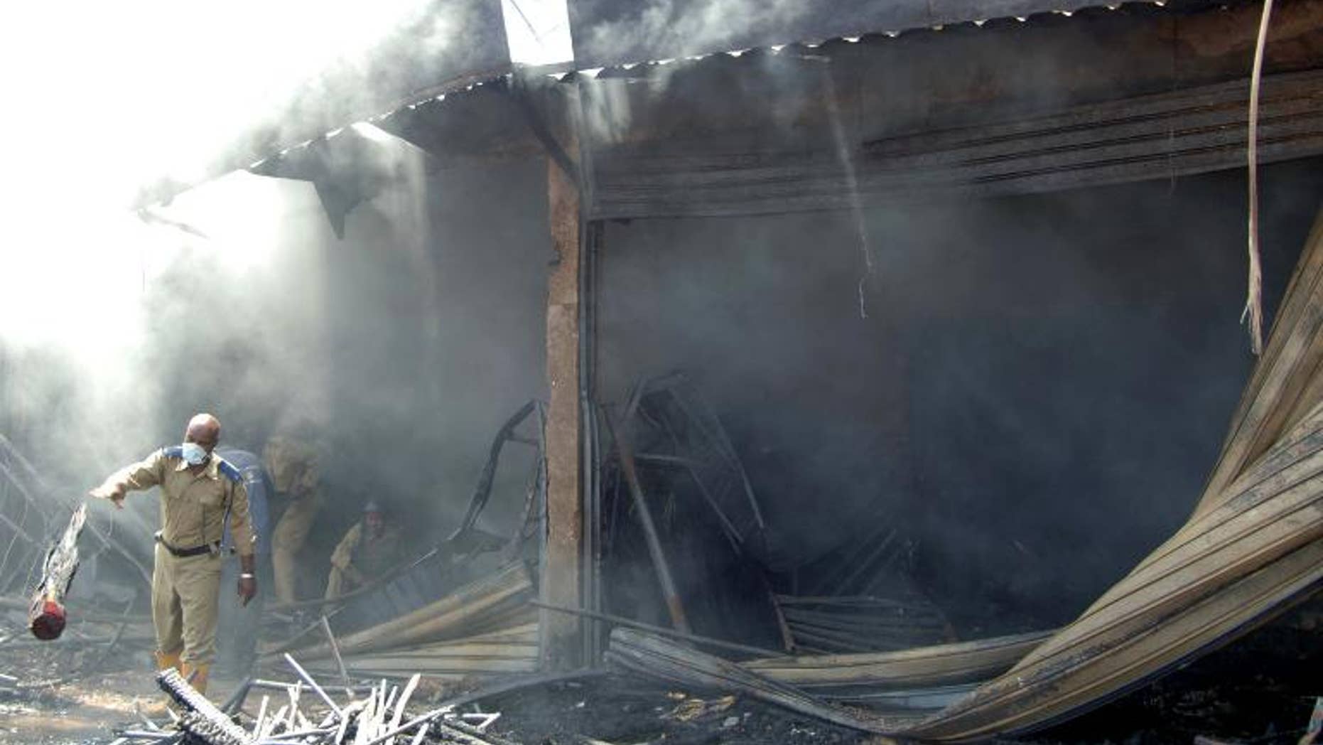 An officer removes debris at the scene of a fire at a popular market in the Sudanese capital Khartoum, on September 29, 2013. About 1,000 people have marched in the Sudanese capital calling for the government's overthrow