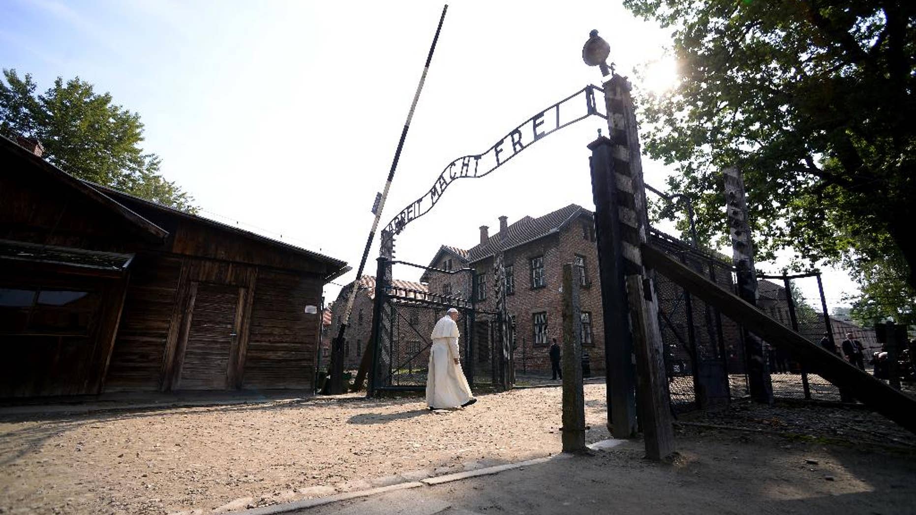 Pope Francis walks through the gate of the former Nazi German death camp of Auschwitz in Oswiecim, Poland, Friday, July 29, 2016. Pope Francis paid a somber visit to the Nazi German death camp of Auschwitz-Birkenau Friday, becoming the third consecutive pontiff to make the pilgrimage to the place where Adolf Hitler's forces killed more than 1 million people, most of them Jews. (Filippo Monteforte/Pool Photo via AP)