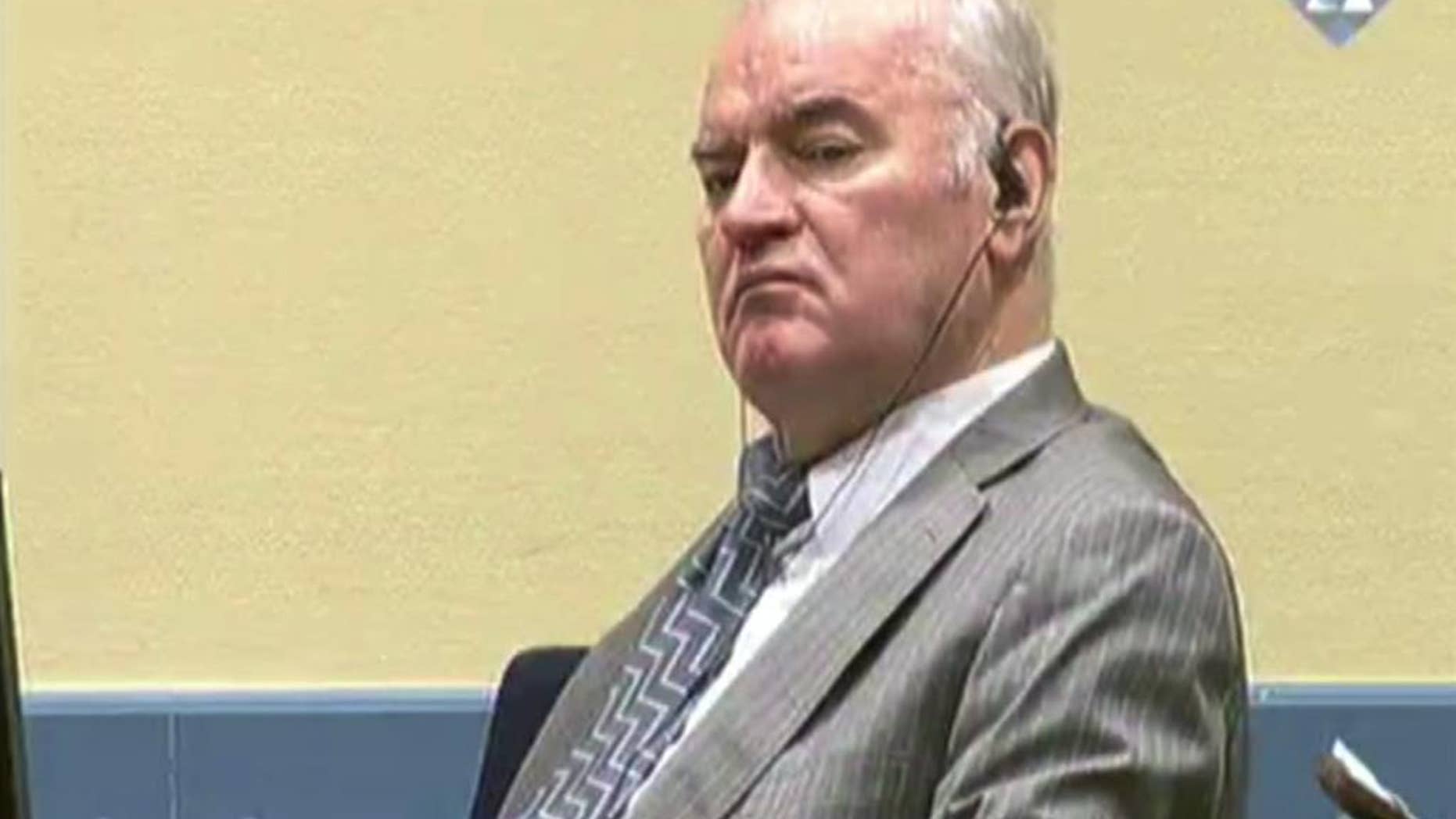 FILE - This is a Monday Dec. 5, 2016 file photo of Former Bosnian Serb military chief General Ratko Mladic looks across the court room at the International Criminal Tribunal for the Former Yugoslavia in the Hague Netherlands in this image taken from video. Gen. Ratko Mladic's defense team called on United Nations judges Tuesday Dec. 13, 2016 to acquit the former Bosnian Serb military chief, arguing that prosecutors failed to prove he orchestrated atrocities by Serb forces under his command during the Bosnian War. (ICTY Video, File via AP)