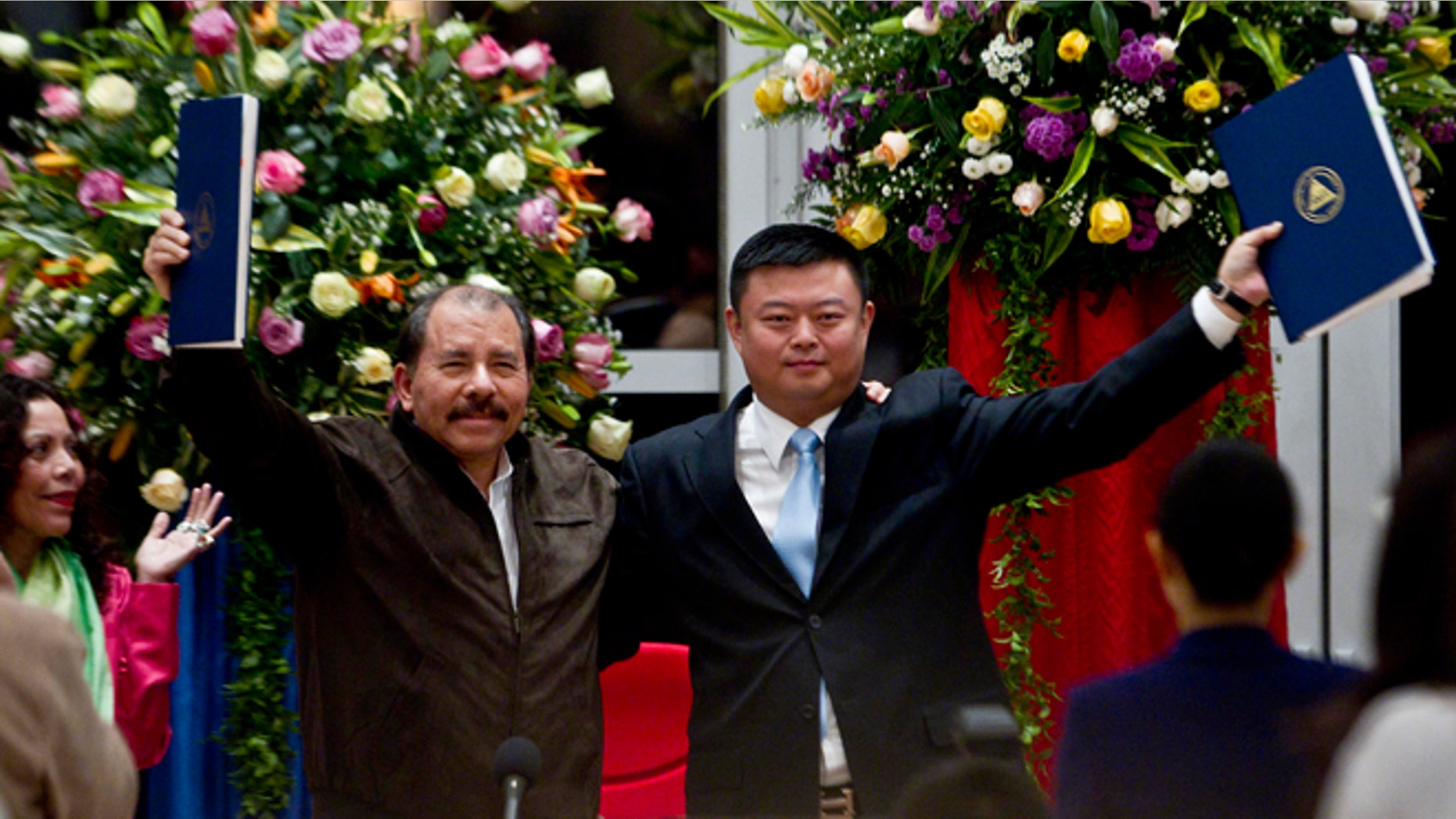 FILE - In this June 14, 2013 file photo, President Daniel Ortega, left, and Chinese businessman Wang Jing hold up a concession agreement for the construction of a multibillion-dollar canal at the Casa de los Pueblos in Managua. Nicaraguas government and Chinas HKND Group on Monday July 7, 2014, unveiled the route of a proposed inter-ocean canal to compete with the Panama Canal that Sandinista officials hope with lift the Central American country out of poverty. (AP Photo/Esteban Felix, File)