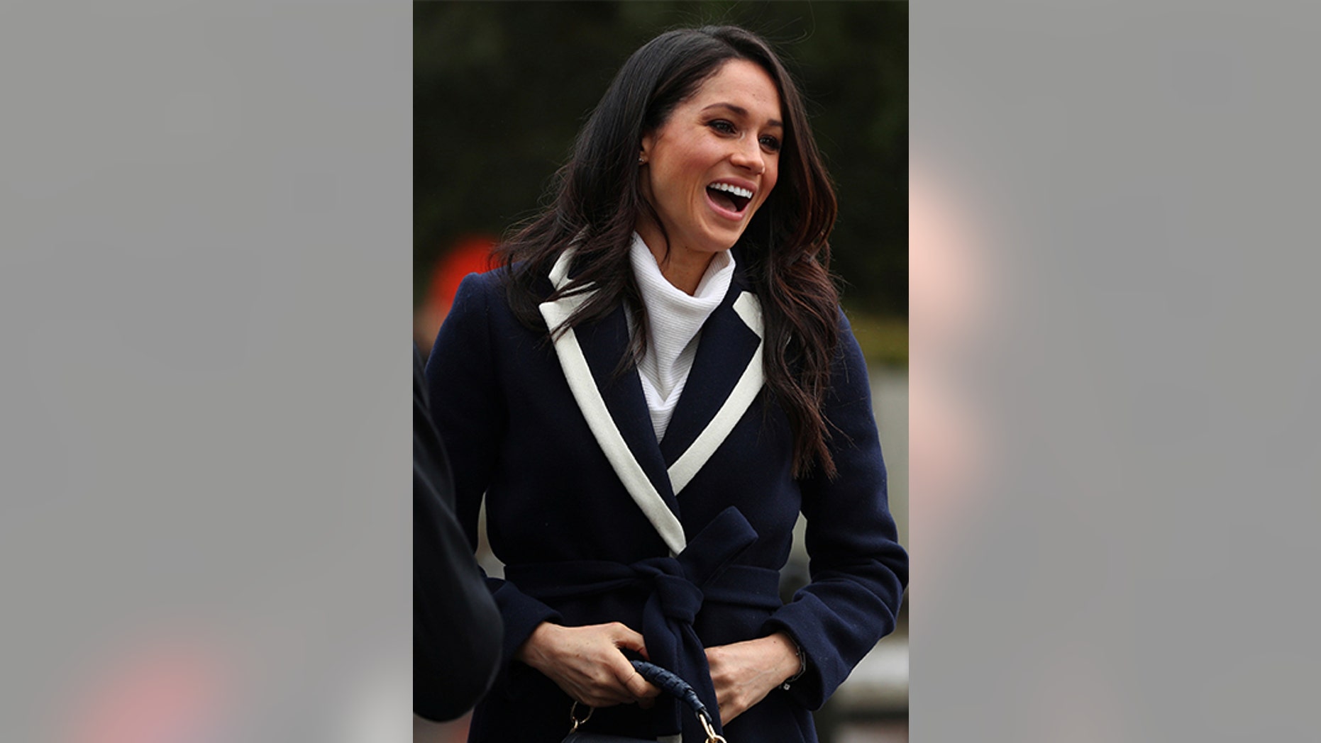 Meghan Markle layered her cozy wrap coat over a white All Saints turtleneck and black cigarette Alexander Wang pants.