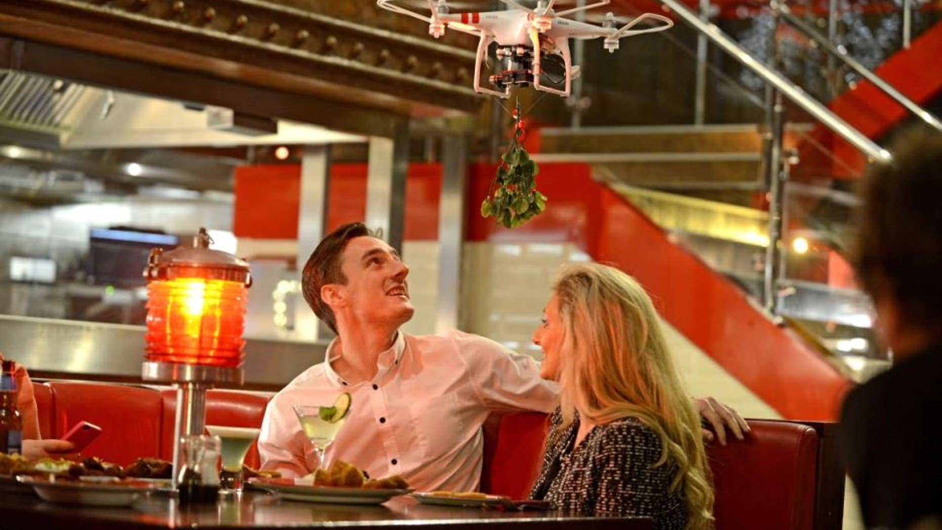 A Mobile Mistletoe drone hovers over a couple.