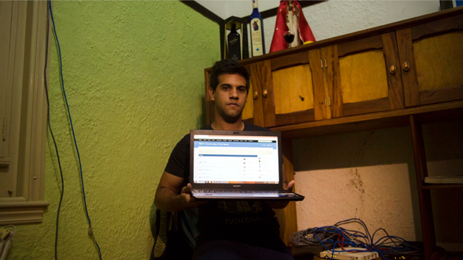 Rafael Antonio Broche Moreno with his computer, modem and intranet network cabling at his home in Havana.