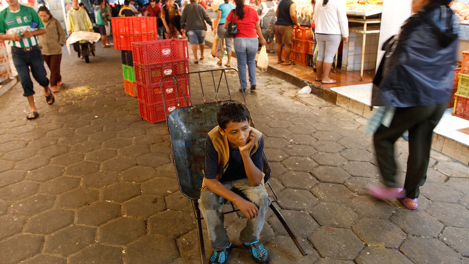 A 12-year-old boy rests as he works as a porter at the El Abasto market in Santa Cruz, Bolivia.