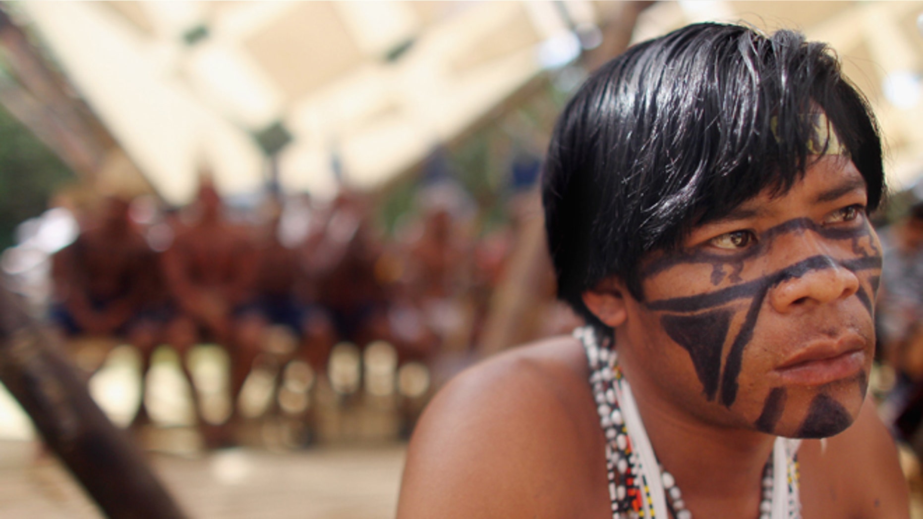RIO DE JANEIRO, BRAZIL - JUNE 19: An indigenous man watches a ceremony at the Kari-Oca village constructed by indigenous peoples as a counter point to the Rio + 20 conference on June 19, 2012 in Rio de Janeiro, Brazil. More than 1,000 indigenous peoples are residing at the site through the conference. Indigenous groups oppose Brazils Amazon forest policies including the controversial Belo Monte dam project. Over 100 heads of state and tens of thousands of participants and protesters will descend on Rio de Janeiro, Brazil, June 20-22 for the high-level portion of the Rio+20 United Nations Conference on Sustainable Development or Earth Summit. Host Brazil is caught up in its own dilemma between accelerated growth and environmental preservation. The Brazilian Amazon, home to 60 percent of the worlds largest forest and 20 percent of the Earths oxygen, remains threatened by the rapid development of the country. The summit aims to overcome years of deadlock over environmental concerns and marks the 20th anniversary of the landmark Earth Summit in Rio in 1992, which delivered the Climate Convention and a host of other promises. Brazil is now the worlds sixth largest economy and is set to host the 2014 World Cup and 2016 Summer Olympics. (Photo by Mario Tama/Getty Images)