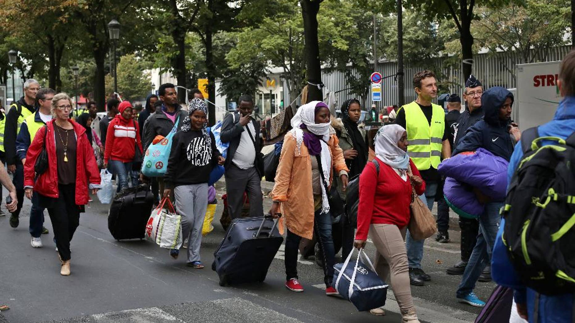 Migrants are evacuated from a camp in the north of Paris, Friday, Sept. 16, 2016. Police and city officials are evacuating hundreds of migrants who had been living on the streets of northern Paris for weeks, in the latest of a string of attempts to find solutions for France's migrants. (AP Photo/Thibault Camus)