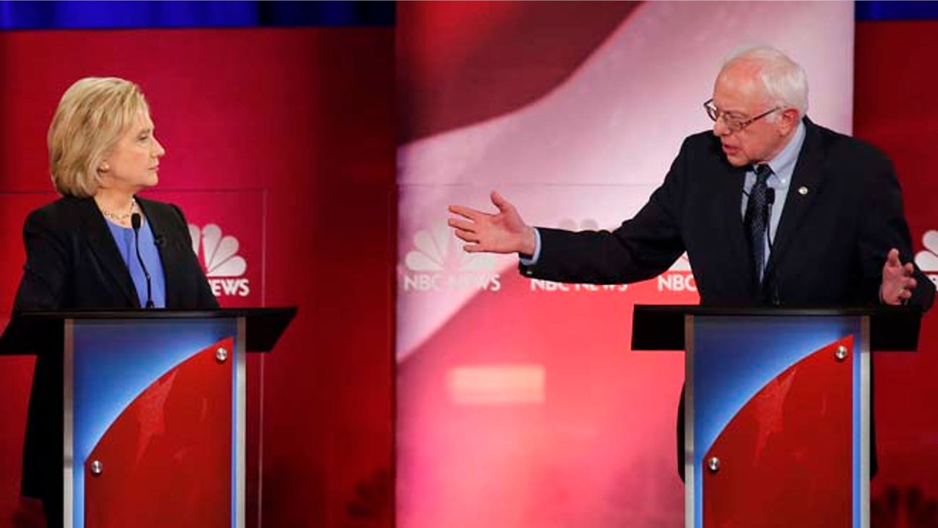 Democratic presidential candidate, Sen. Bernie Sanders, I-Vt., gestures towards Democratic presidential candidate, former Secretary of State Hillary Clinton during a democratic presidential primary debate at the Gaillard Center, Sunday, Jan. 17, 2016, in Charleston, S.C. (AP Photo/Mic Smith)