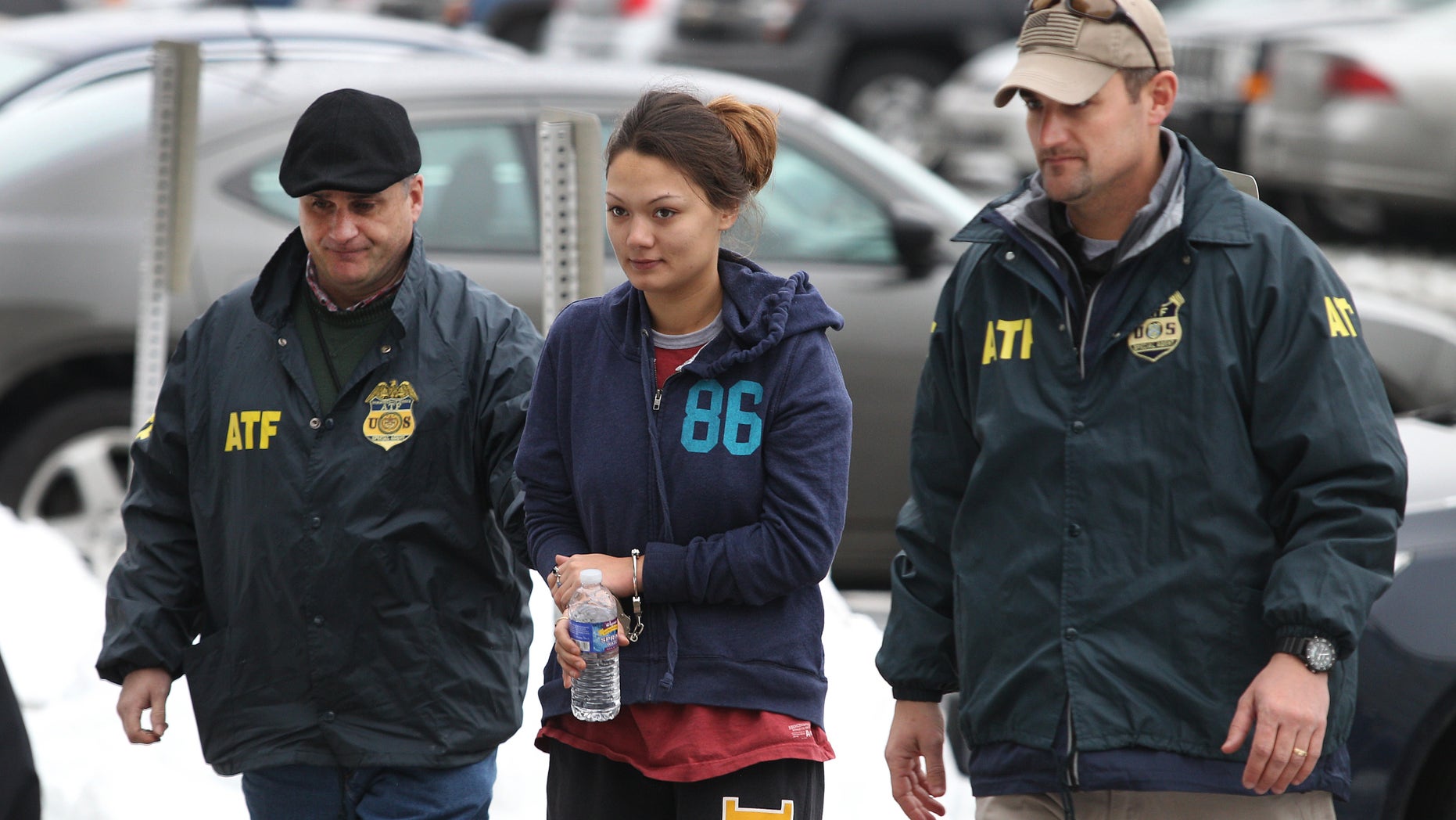 Dawn Nguyen is escorted into the Federal Building, Friday, Dec. 28, 2012, in Rochester, N.Y., and charged in connection with the guns used in the Christmas Eve ambush slaying of two volunteer firefighters responding to a house fire in Webster, N.Y. (AP Photo/Democrat & Chronicle, Jamie Germano) MAGS OUT; NO SALES; MANDATORY CREDIT; INTERNET OUT