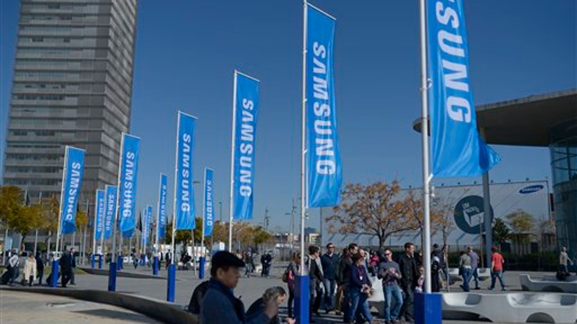 Visitors walk outside the Mobile World Congress, the world's largest mobile phone trade show, in Barcelona, Spain, Sunday, Feb. 23, 2014. (AP Photo/Manu Fernandez)