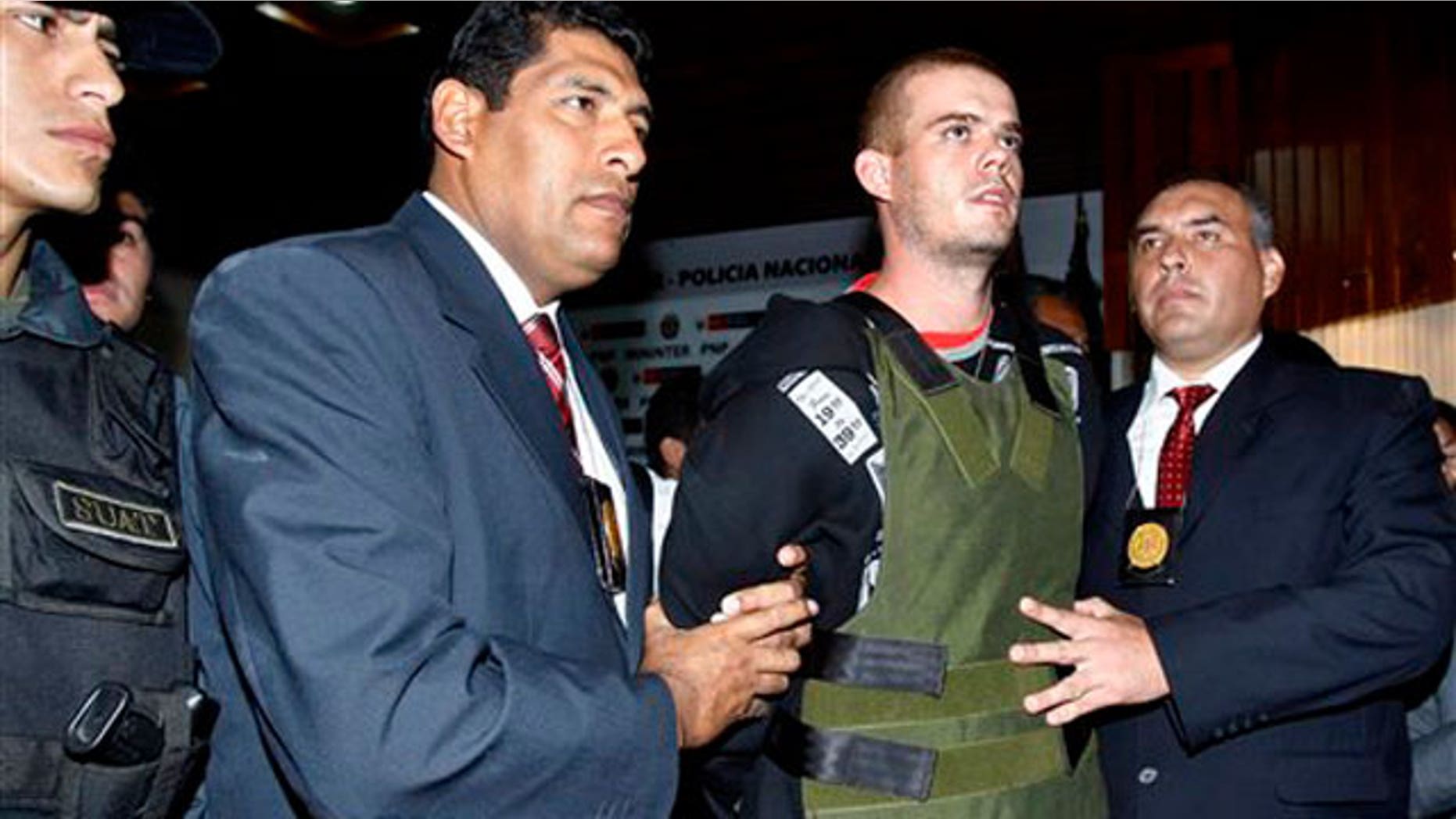 June 5, 2010: Police officers escort Joran van der Sloot, second right, during a press conference at a police station in Lima, Peru.
