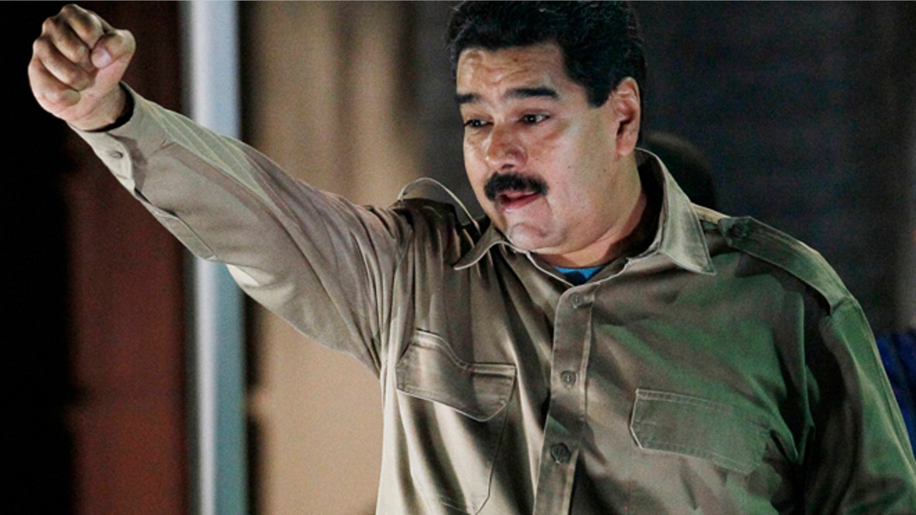 Venezuela's President Nicolas Maduro holds the documents granting him emergency decree powers as he gestures to supporters at Miraflores presidential palace in Caracas, Venezuela, Tuesday, Nov. 19, 2013. Venezuela's congress granted Maduro emergency decree powers that will allow him to approve laws without consulting congress for up to a year. (AP Photo/Ariana Cubillos)