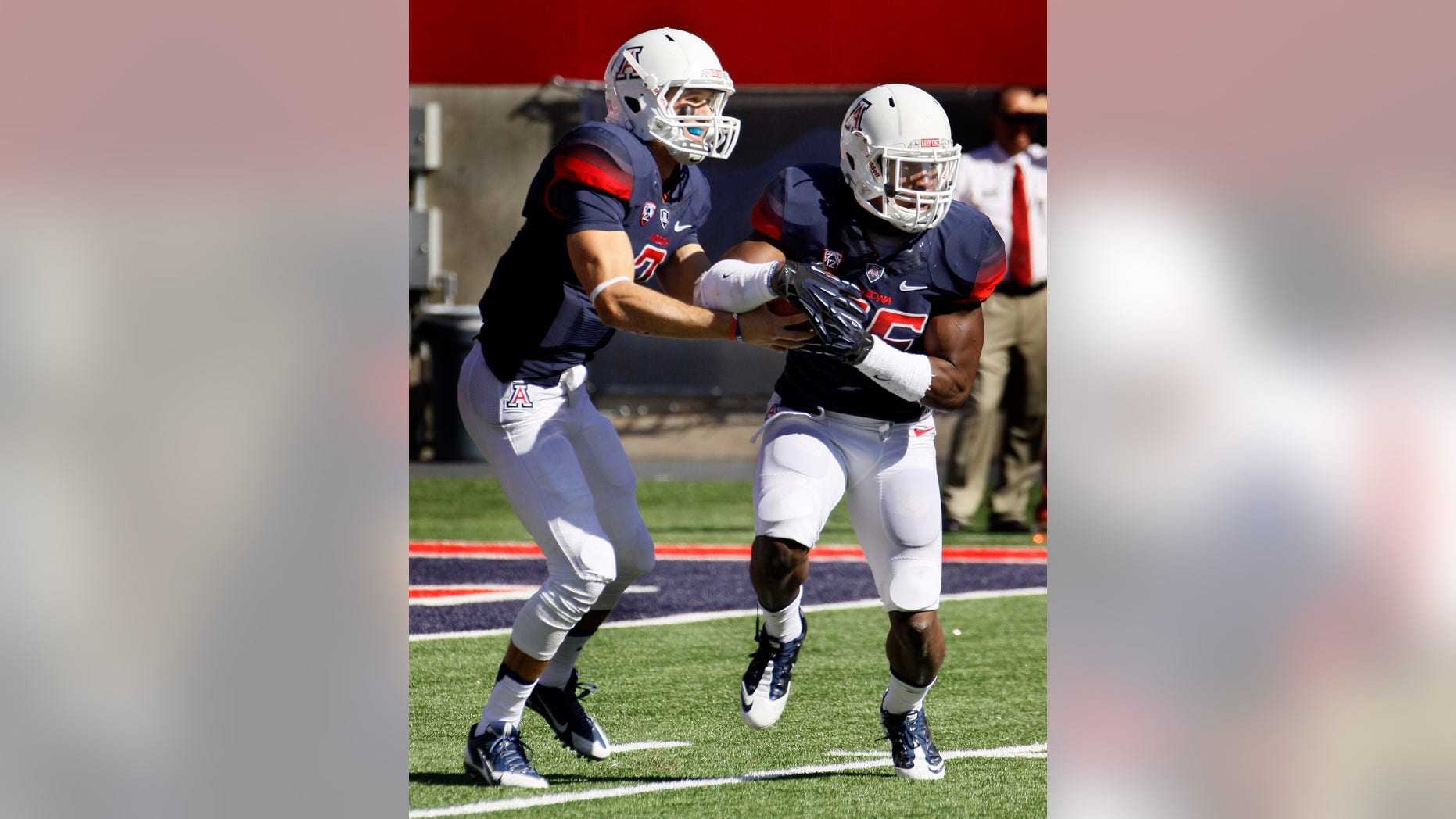 Arizona's starting quarterback B.J. Denker, left, hands off the ball to Ka'Deem Carey in the first half of an NCAA college football game against Washington State, Saturday, Nov. 16, 2013, in Tucson, Ariz. (AP Photo/Wily Low)