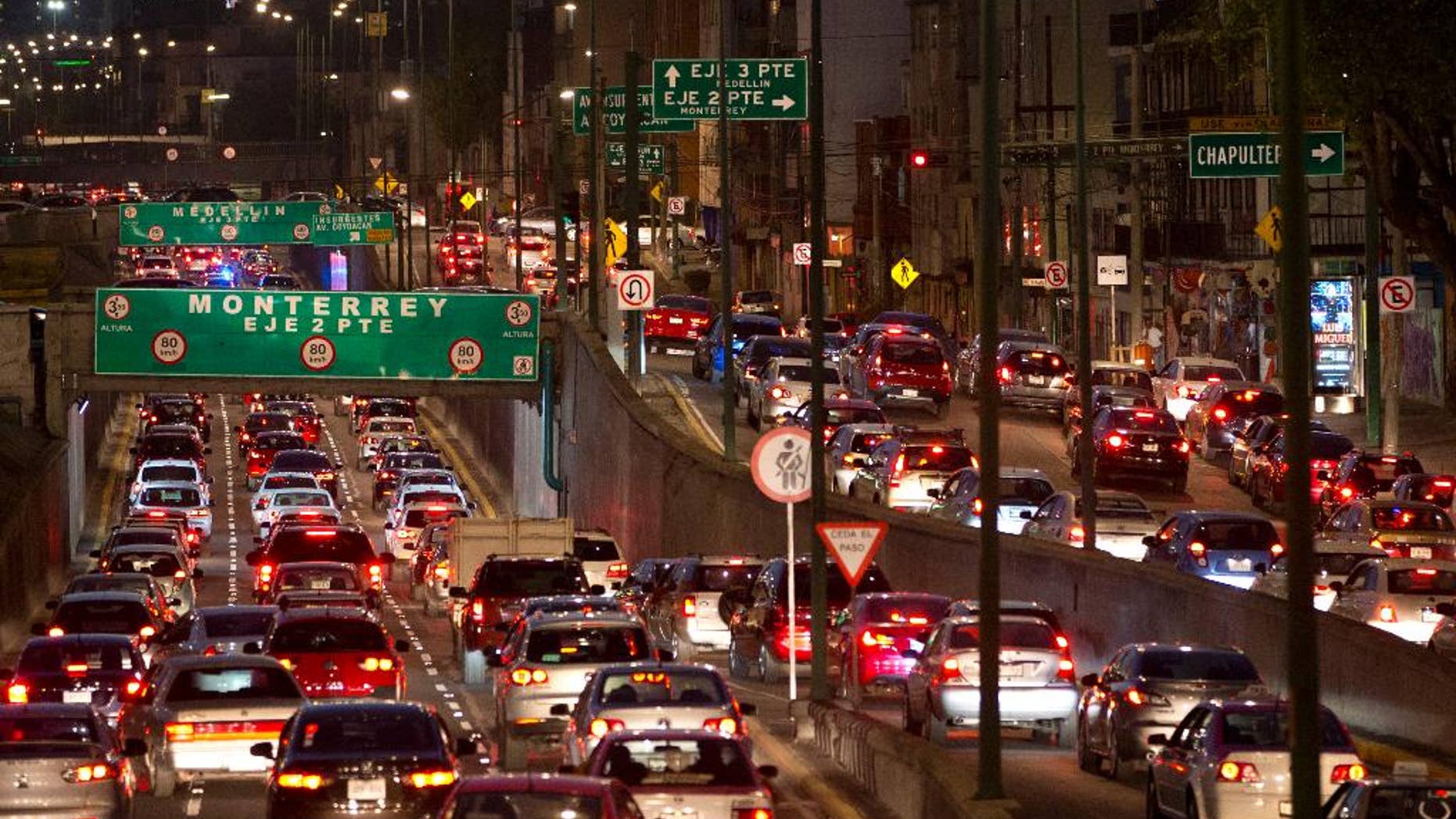 FILE - In this March 30, 2016, file photo, cars sit in evening rush hour traffic in Mexico City. Under rules that took effect Tuesday, April 5, 2016, and with the city heading into a second day of a pollution alert, authorities ordered 40 percent of cars to stay home Wednesday. The ban covers over 2 million cars in the metropolitan area, which has about 20 million residents. (AP Photo/Rebecca Blackwell, File)