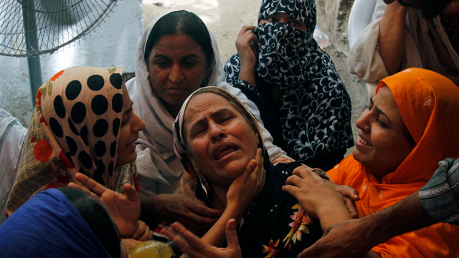 Aug. 19: People comfort a woman who lost her son in Karachi, Pakistan.