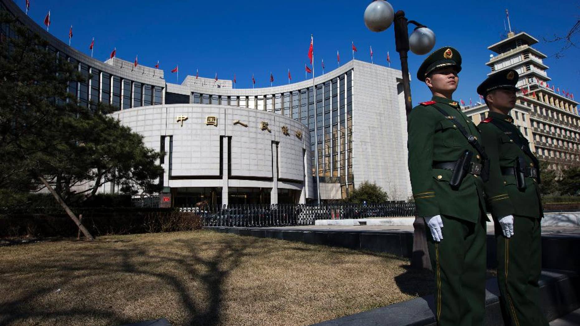 FILE - In this Wednesday, March 13, 2013 file photo, Chinese paramilitary policemen stand on duty outside the People's Bank of China in Beijing, China. China's central bank said Sunday, May 10, 2015, that it is cutting interest rates for the third time in six months to boost the country's sluggish economy. (AP Photo/Ng Han Guan, File)