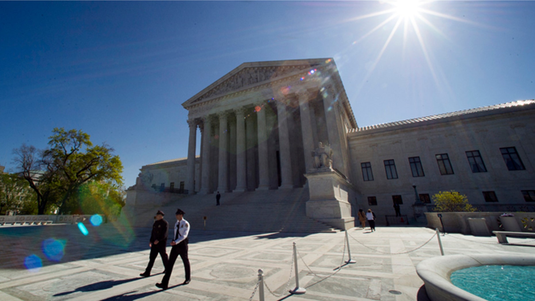 Supreme Court police officers walk on the plaza in front of the Supreme Court in Washington, Tuesday, April 28, 2015. The Supreme Court is set to hear historic arguments in cases that could make same-sex marriage the law of the land. The justices are meeting Tuesday to offer the first public indication of where they stand in the dispute over whether states can continue defining marriage as the union of a man and a woman, or whether the Constitution gives gay and lesbian couples the right to marry. (AP Photo/Cliff Owen)