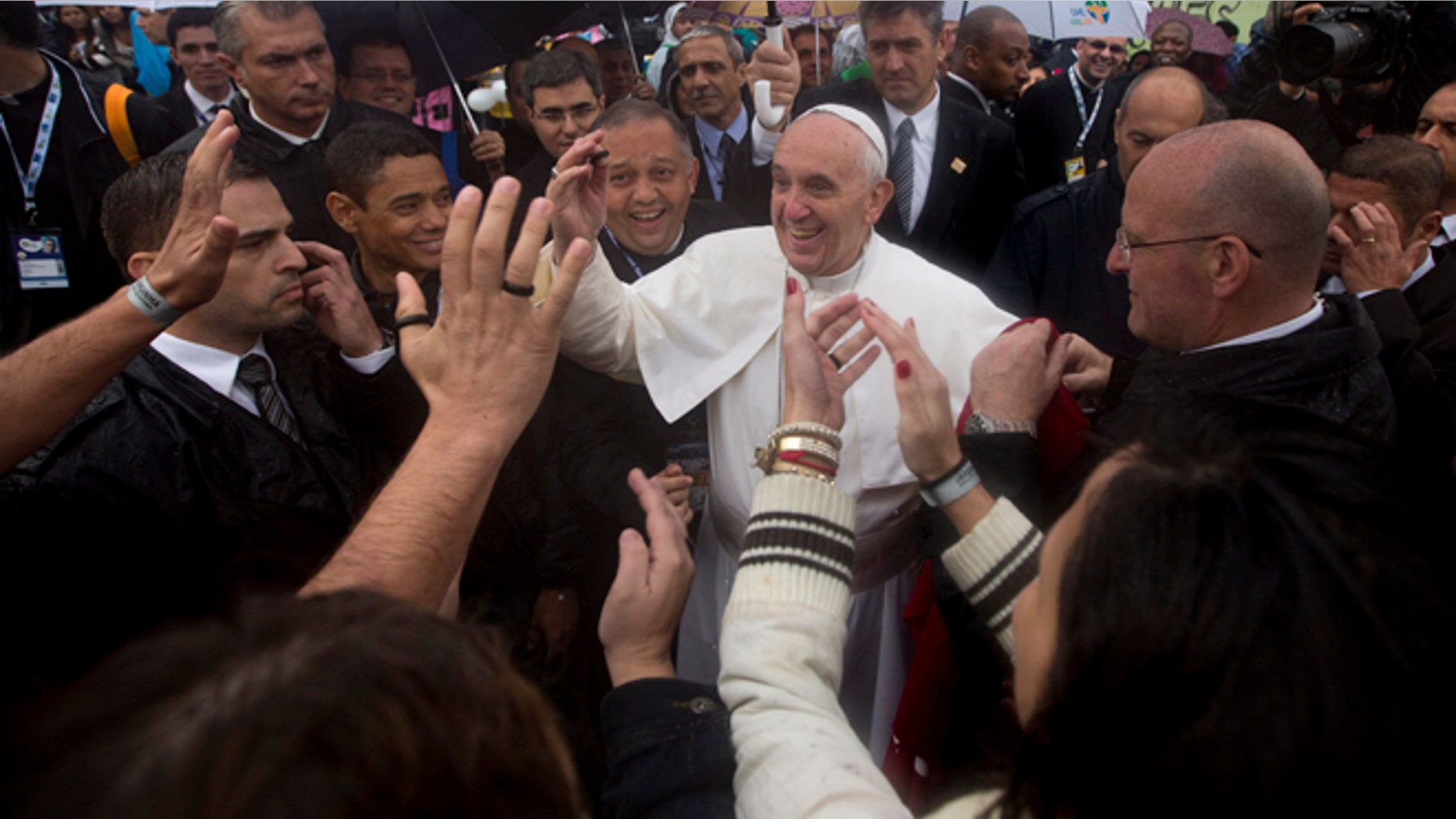 July 25, 2013: People greet Pope Francis, center, as he visits the Varginha slum in Rio de Janeiro, Brazil.