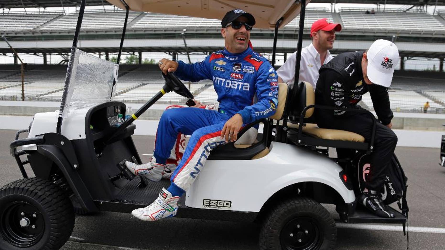Tony Kanaan, of Brazil, laughs as Sage Karam looks at a flat tire on the cart they where riding in before the start of practice for the Indianapolis 500 auto race at Indianapolis Motor Speedway in Indianapolis, Monday, May 18, 2015. (AP Photo/Michael Conroy)