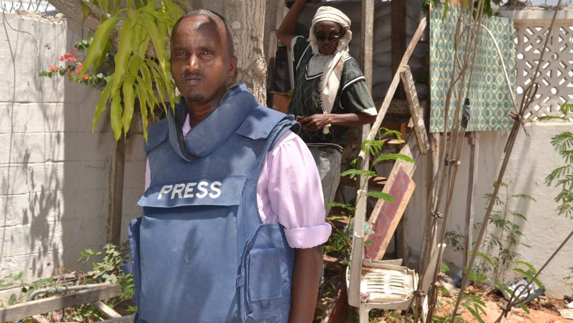 In this photo taken Saturday, March 22, 2014, Somali journalist Abdiaziz Mohamed Ali Haji, ,left, stands in radio Shabelle compound in Mogadishu, Somalia. Abdiaziz Mohamed Ali Haji, a reporter for Shabelle radio, was shot dead by unidentified gunmen on his way to home in the north of the capital city, said Abdirizak Turyare, a producer at the radio station. (AP Photo/Farah Abdi Warsameh,)