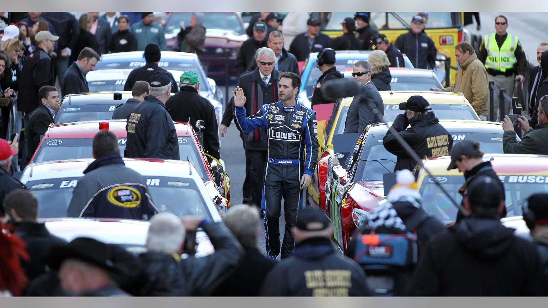 Jimmie Johnson waves to the crowd as he is introduced before leading a victory lap on the Las Vegas Strip during NASCAR Champions Week on Thursday, Dec. 5, 2013, in Las Vegas. (AP Photo/Isaac Brekken)