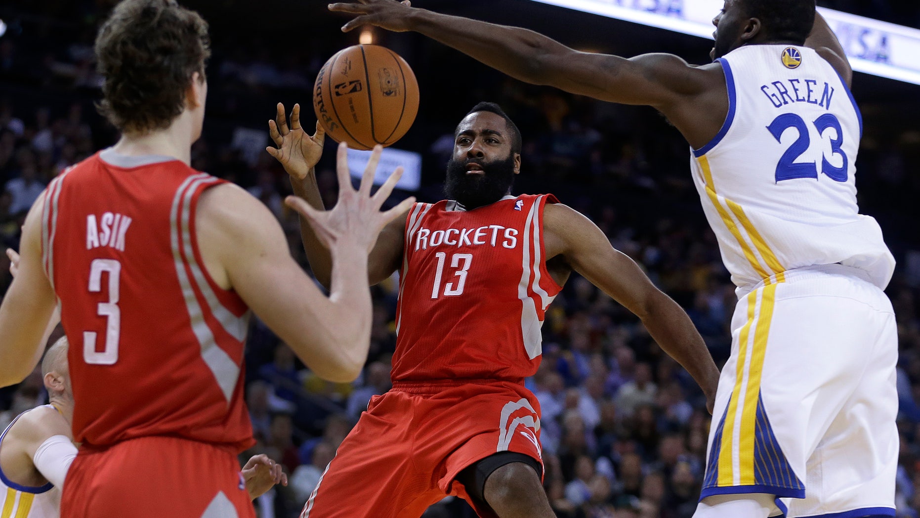 Houston Rockets' James Harden (13) passes away from Golden State Warriors' Draymond Green (23) to Omer Asik (3) during the second half of an NBA basketball game Thursday, Feb. 20, 2014, in Oakland, Calif. (AP Photo/Ben Margot)
