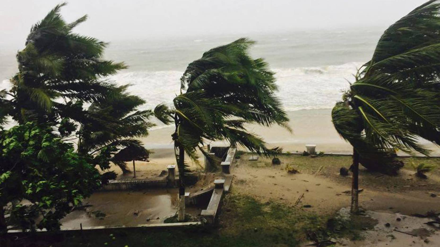 Trees are lashed by strong winds in Sambava, Madagascar Tuesday, March 7, 2017 as heavy rains and strong winds from a cyclone hit northeast Madagascar, raising concerns about flooding and landslides. Aid workers were on alert as Cyclone Enawo lashed the coastline. The storm was expected to move south through the island nation for several days, affecting the capital of Antananarivo along the way. (AP Photo/Manny Horsford)
