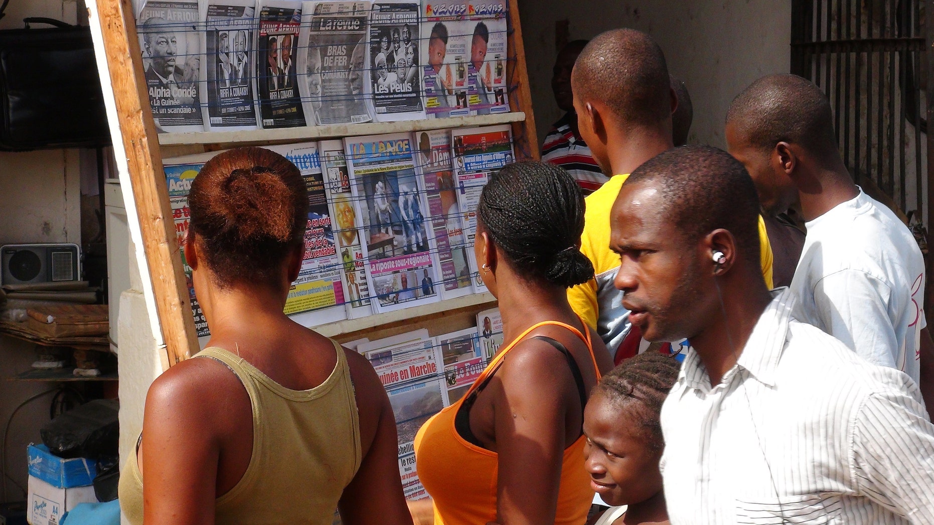 People read news headlines at a newsstand in Conakry, Guinea, March 28, 2014. (REUTERS/Saliou Samb)