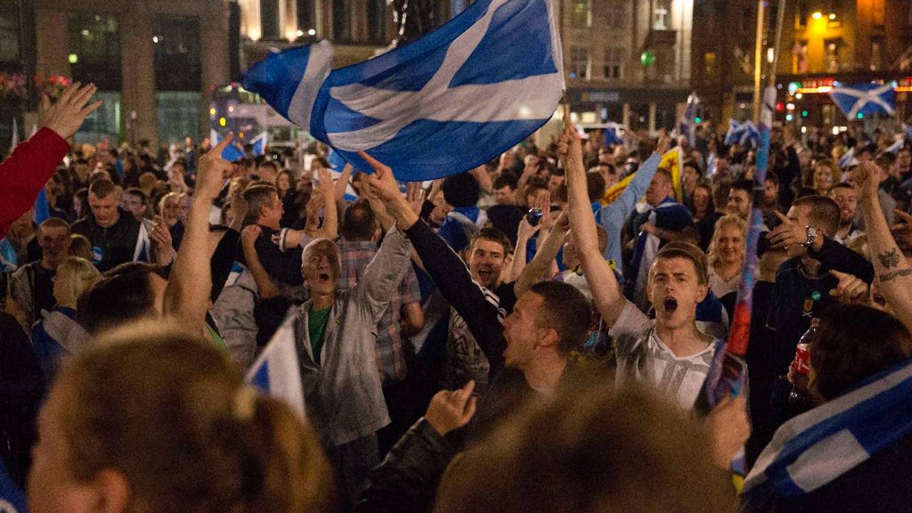 FILE - In this Thursday, Sept. 18, 2014 file photo, supporters of the Yes campaign in the Scottish independence referendum cheer with Scottish Saltire flags as they await the result after the polls closed, in George Square, Glasgow, Scotland. Why Vote Again? Scottish voters decided in a 2014 referendum that they wanted to keep their ties to the U.K. rather than become an independent country. The vote wasn’t particularly close, and it’s not clear if sentiments have changed since then. (AP Photo/Matt Dunham, File)
