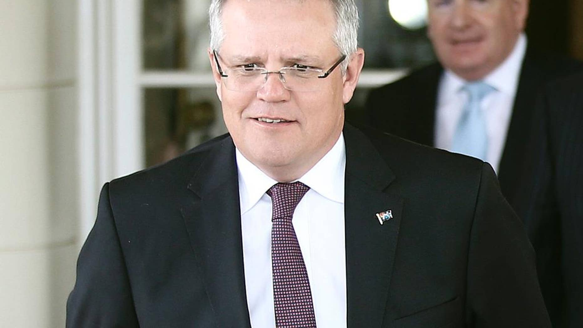 FILE - In this July 19, 2016 file photo, Australia's Treasurer Scott Morrison walks out after he was sworn into office at Government House in Canberra, Australia. Morrison on Friday, Aug. 12, 2016 rejected accusations that the true reason his government plans to ban Chinese bidders from leasing a Sydney electricity grid is to appease influential lawmakers with xenophobic views. (AP Photo/Rob Griffith, File)