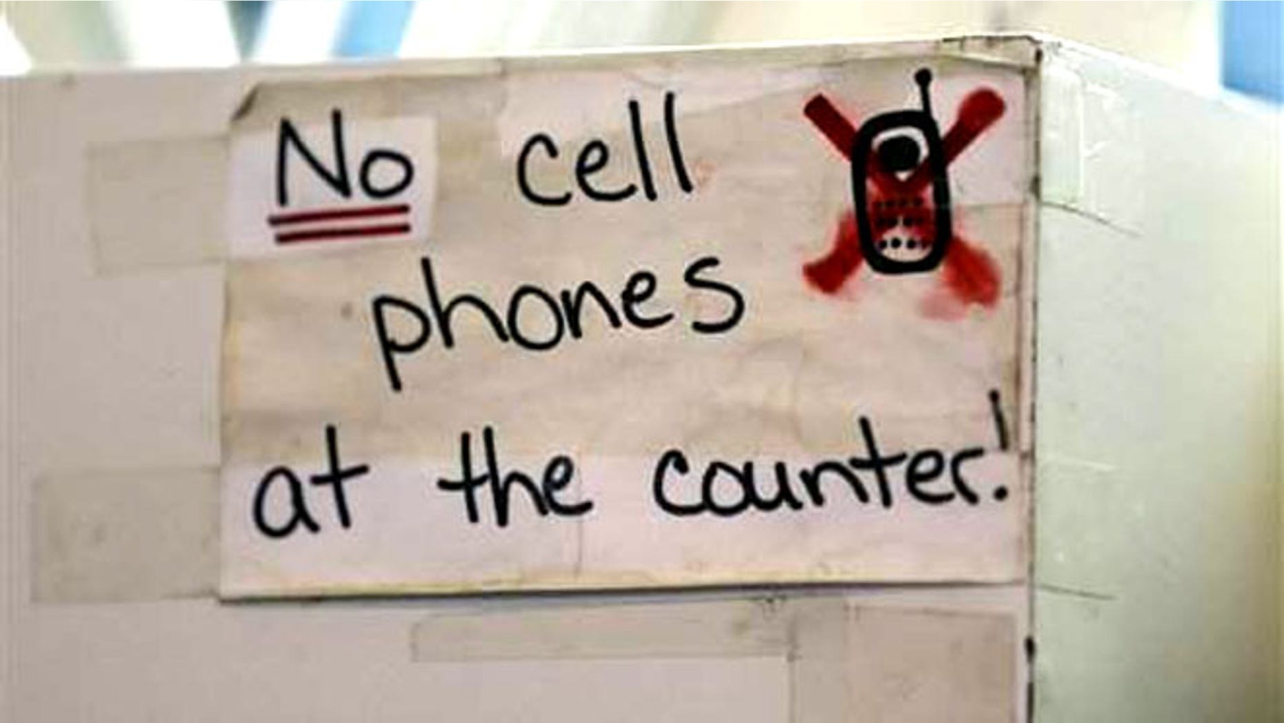 FILE: A sign at the Hamilton Street Cafe advises customers about cell phone policy at the restaurant, in Albany, N.Y.