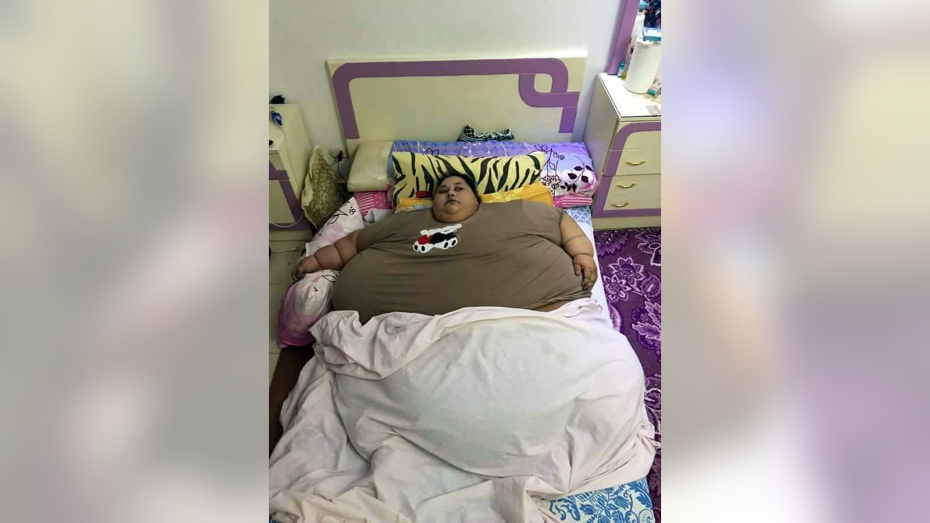 Pic shows: Iman Ahmad Abdulati.
An Egyptian woman is believed to be the fattest woman alive after her weight reached an incredible 79 stone.
Iman Ahmad Abdulati, 36, from Alexandria in northern Egypt, who now weighs 78.7 stone (1,102 lbs or around 500 kilogrammes), said she had not left home for 25 years because of her weight problem, and sitting at home all day she simply got fatter and fatter.
She said that enquiries at local hospitals by her family had not bought a solution, but after her sister Chaymaaâ Ahmad Abdulati went public with the problem, she is now hoping to get help.
Chaymaa said that the household consists of her and her sister and their mother and that their father had died when the girls were young.
Mother and daughter said a lot of their time is spent trying to care for Iman, including feeding and cleaning her and providing her with help in going to the toilet, as she could no longer walk there.
They said that the woman had ended up at home from the age of 11 after suffering what they believe was a stroke that left her bedridden.
Prior to that Imanâs problem appeared at birth when she was born weighing 5 kilogrammes (11 lbs) and had continued growing, struggling to walk even as a young girl because of her weight and then eventually suffering a stroke after which there was no chance for her to lose any weight.
She never attended school because of her weight problem, and medics believe her condition is caused by a fluid retention problem meaning that large amounts of extra water are being retained in her body.
(ends)Â Â