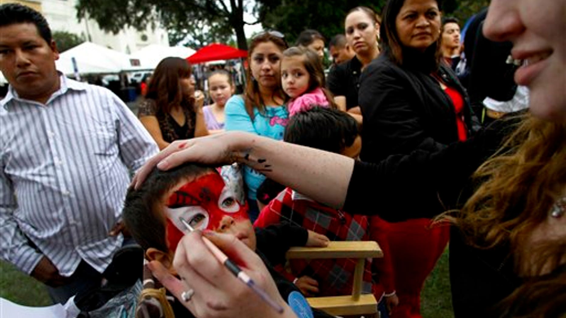 In this photo taken Sunday Sept. 18, 2011, Roan McGee, 3, gets his face painted during the Fiesta del Pueblo festival in Raleigh, N.C. According to the 2010 population census, even though the population with Mexican roots is still the largest Hispanic community in the state, people from Central America, the Caribbean and South America have seen their members largely increase in the last decade. (AP Photo/Jim R. Bounds)