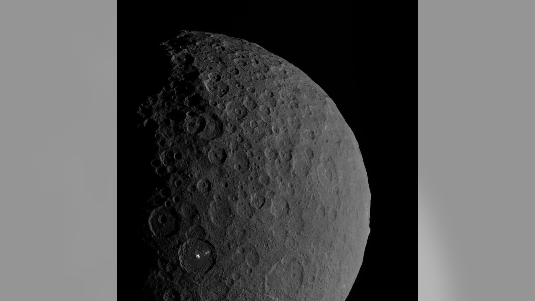 This view of the dwarf planet Ceres shows the mountain and likely "ice volcano" Ahuna Mons on the right edge and the bright spots of the Occator crater in the bottom left. New research suggests that multiple ice volcanoes once dotted Ceres' surface. (Credit: NASA/JPL-Caltech/UCLA/MPS/DLR/IDA)