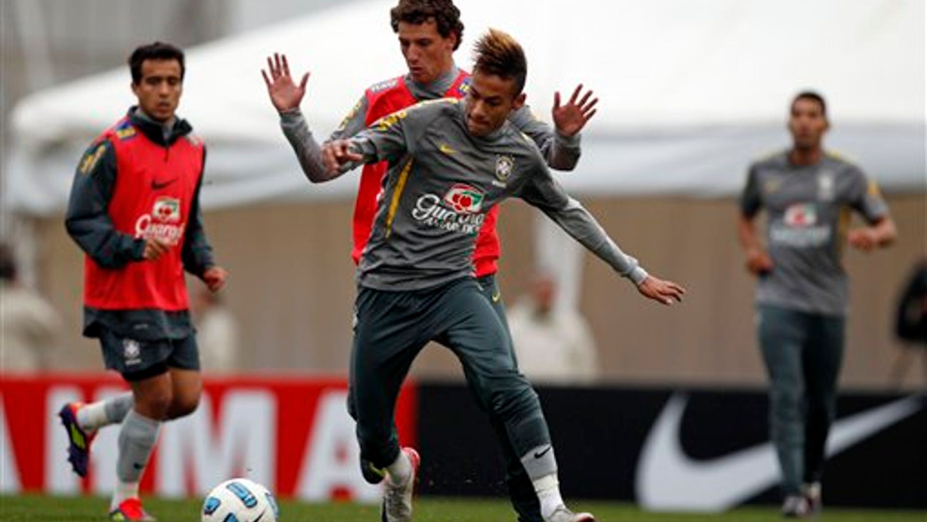 July 15: Brazil's Elano and Neymar, fight for the ball during a training session near Campana, Argentina.