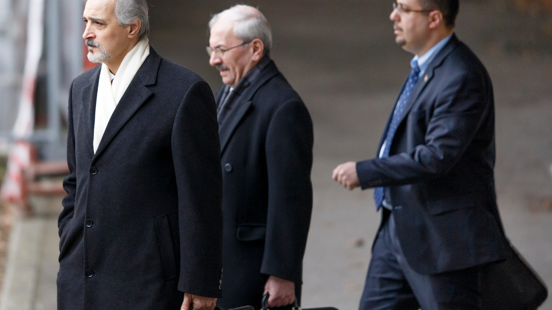 Syrian chief negotiator Bashar Ja'afari, left, Ambassador of the Permanent Representative Mission of the Syria to UN New York, leaves the meeting, at the European headquarters of the United Nations, in Geneva, Switzerland, Sunday, Jan. 26, 2014. Syrians on opposite sides of their country’s civil war tried again Sunday to find common ground, with peace talks focusing on an aid convoy to a besieged city that once more came under mortar attack from the government. (AP Photo/Keystone,Salvatore Di Nolfi)
