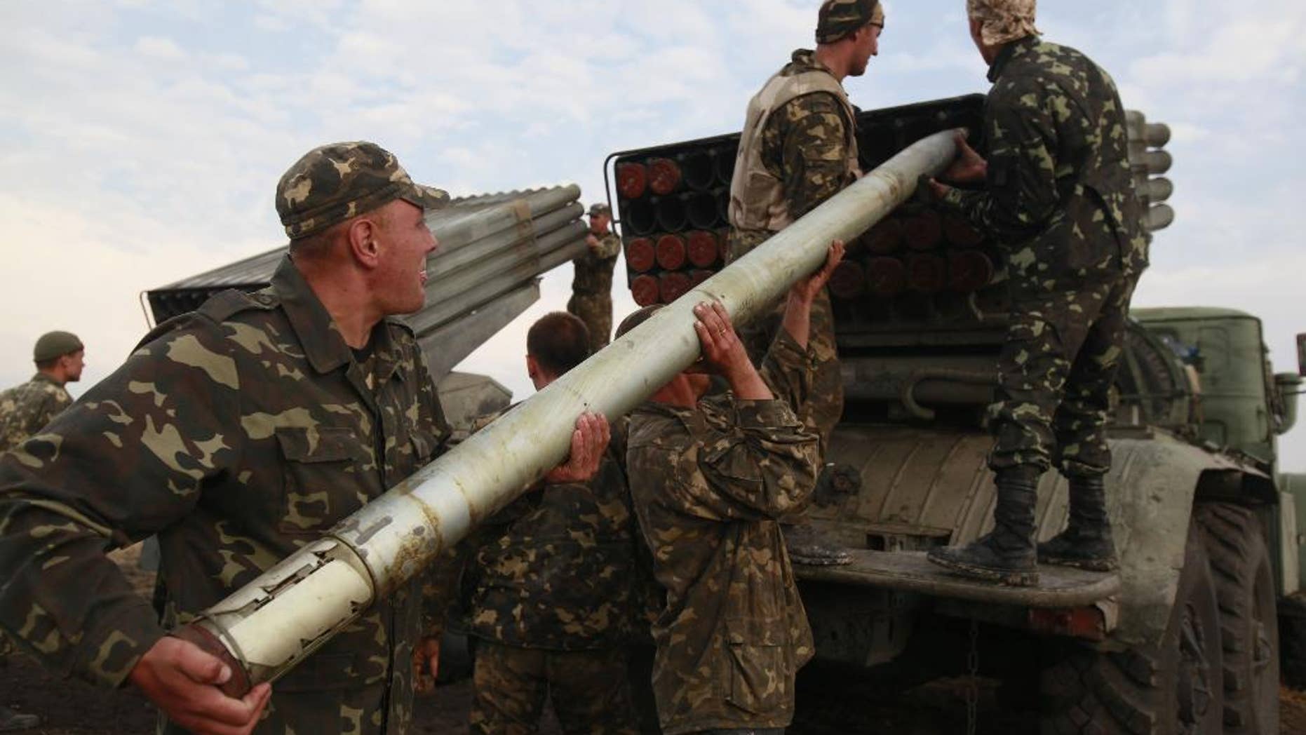 Aug. 18, 2014: Ukrainian soldiers load a Grad missile during fighting with pro-Russian separatists close to Luhansk, eastern Ukraine. Dozens of civilians were killed Monday when separatist rebels shelled a convoy of refugees trying to flee war-torn eastern Ukraine, a top Ukrainian official said. A top rebel chief said no such attack had occurred.