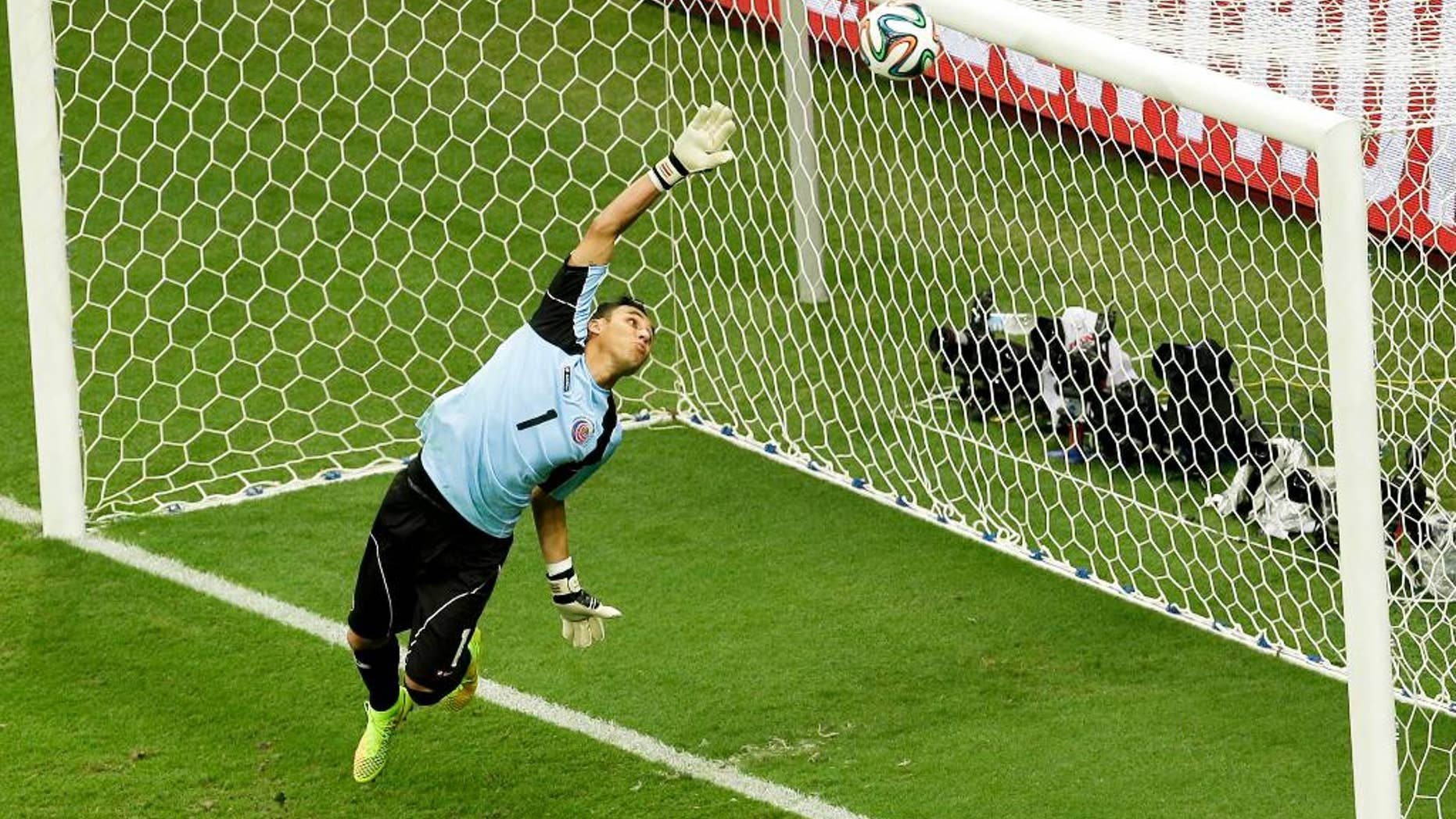 Costa Rica's goalkeeper Keylor Navas dives as the ball hits the bar during the World Cup quarterfinal soccer match between the Netherlands and Costa Rica at the Arena Fonte Nova in Salvador, Brazil, Saturday, July 5, 2014. (AP Photo/Themba Hadebe)
