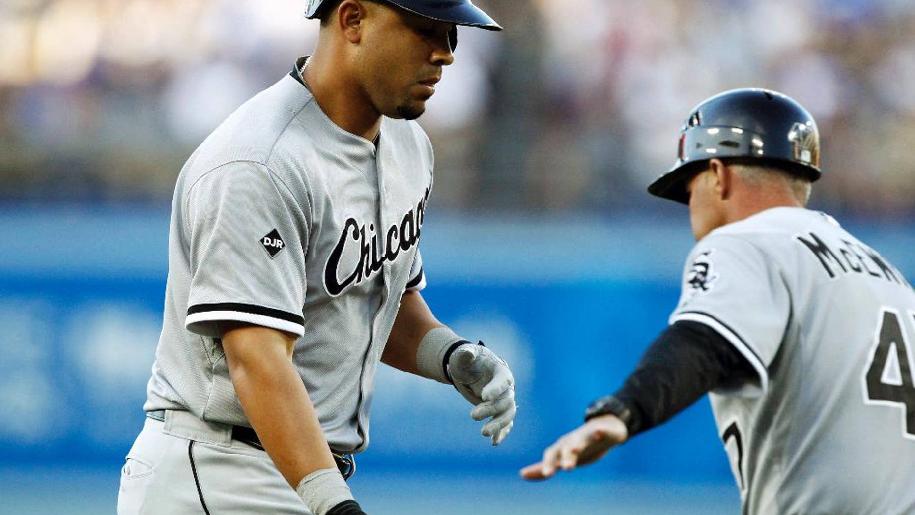 Chicago White Sox third base coach Joe McEwing, right, congratulates Jose Abreu rounding third after hitting a two-run home run against the Los Angeles Dodgersin the first inning of a baseball game on Tuesday, June 3, 2014 in Los Angeles. (AP Photo/Alex Gallardo)