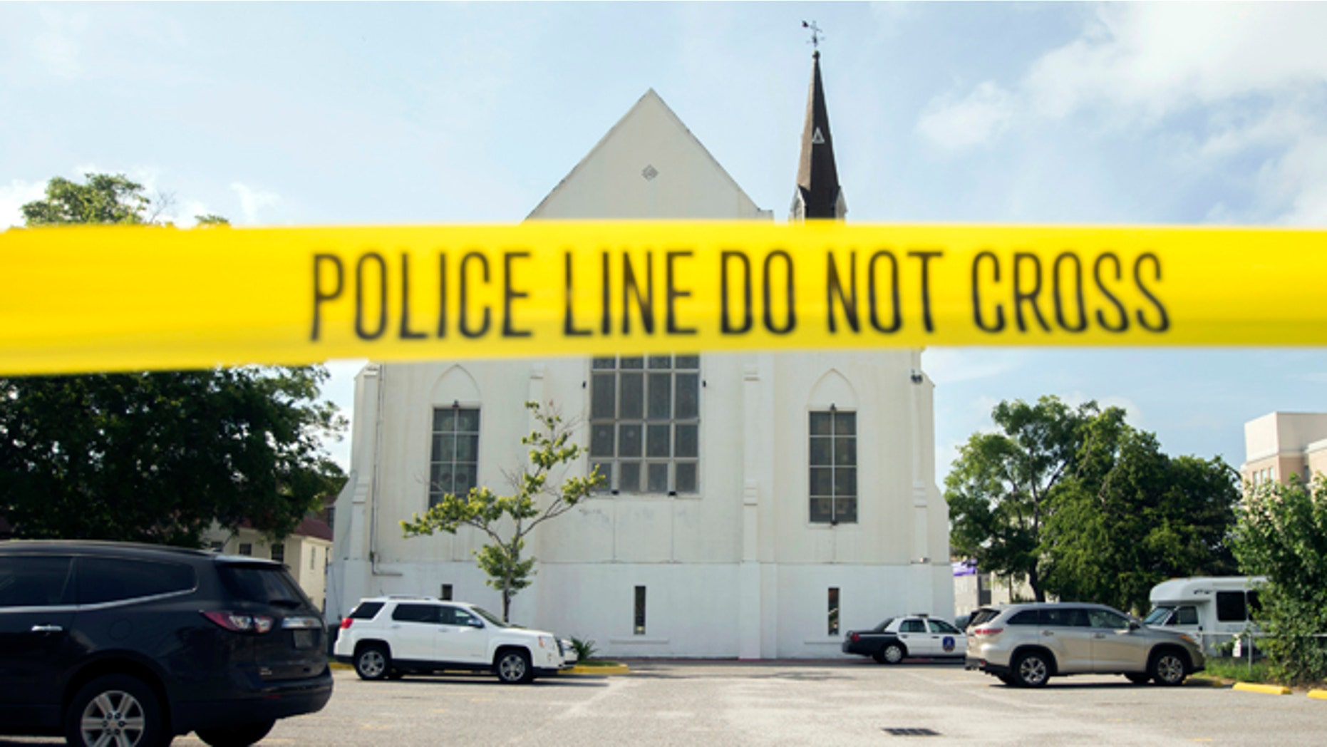 June 19, 2015: Police tape surrounds the parking lot behind the AME Emanuel Church as FBI forensic experts work the crime scene in Charleston, S.C.