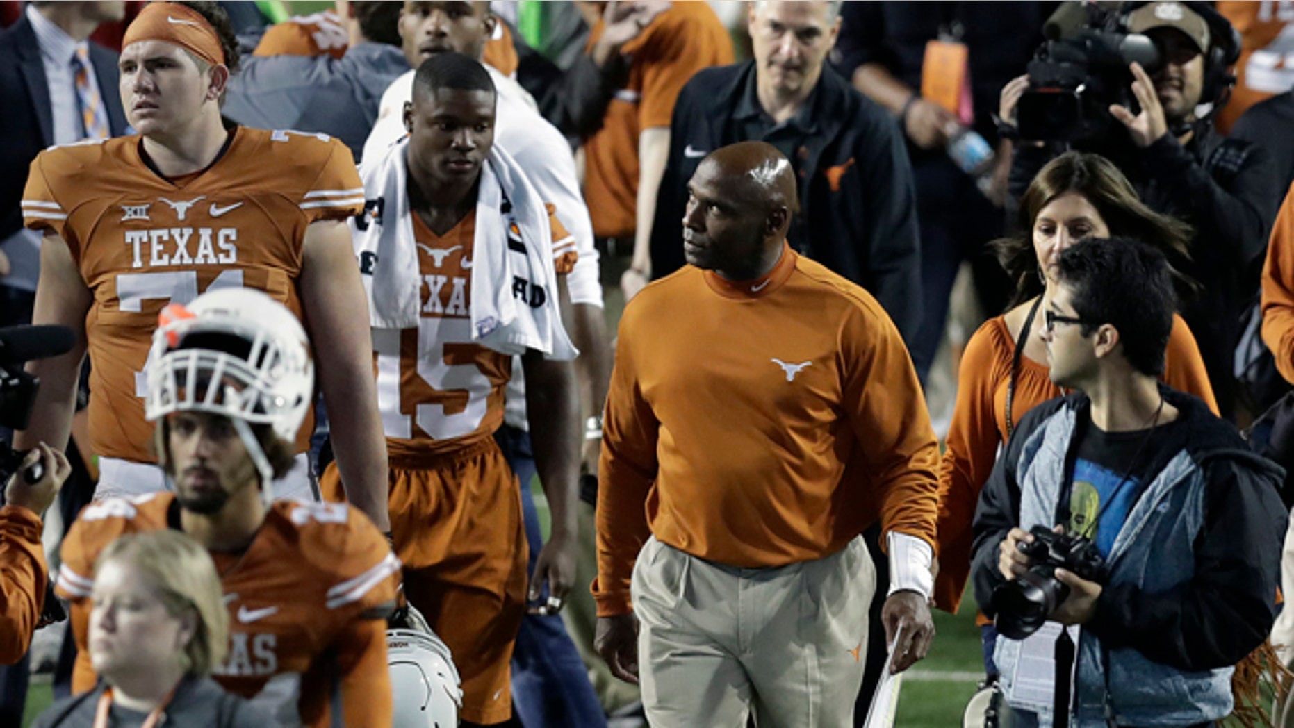 Texas head coach Charlie Strong, center, looks to the stands as he walks off the field with his team following an NCAA college football game against TCU, Friday, Nov. 25, 2016, in Austin, Texas. TCU won 31-9. (AP Photo/Eric Gay)