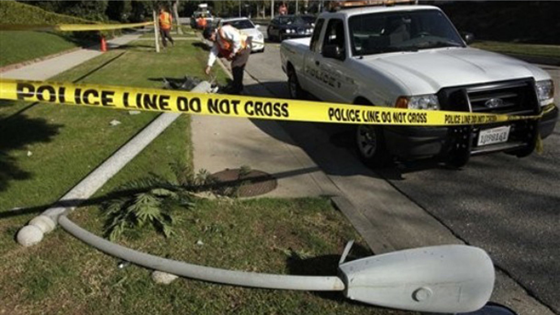 Nov. 16: A utility worker examines the site of the crash where Chasen was found inside her vehicle shot several times in the chest and killed, afterward crashing into this light pole (AP).