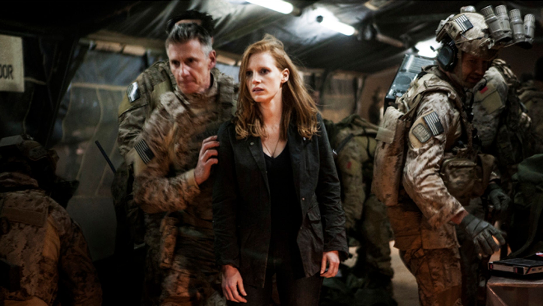 In this undated publicity photo released by Columbia Pictures Industries, Inc., Jessica Chastain, center, plays a member of the elite team of spies and military operatives, stationed in a covert base overseas, with Christopher Stanley, left, and Alex Corbet Burcher, right, who secretly devote themselves to finding Usama Bin Laden in Columbia Pictures' new thriller, "Zero Dark Thirty."