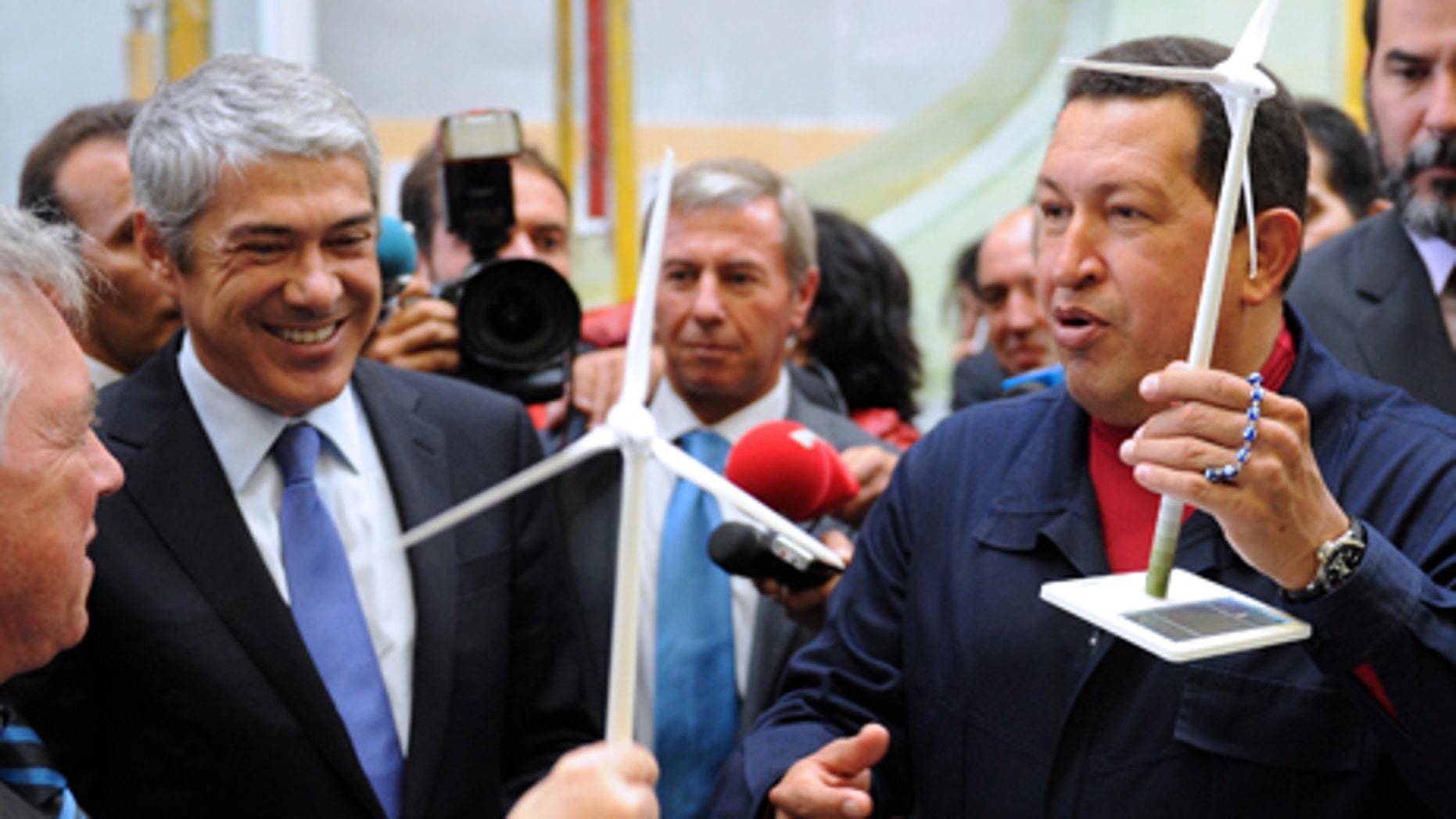 El presidente venezolano Hugo Chávez, derecha, y el primer ministro portugués José Sócrates reciben como regalo un aerogenerador en miniatura durante una visita a una fábrica de estos generadores de electricidad en el astillero Viana do Castelo, en Portugal, el domingo 24 de octubre del 2010. (AP foto/Paulo Duarte)
