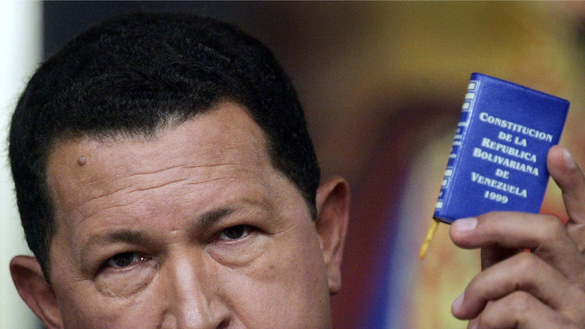 CARACAS, VENEZUELA - DECEMBER 05: Venezuelan President Hugo Chavez speaks at a press conference while holding a copy of the Venezuelan constitution in Miraflores Palace December 5, 2006 in Caracas, Venezuela. Chavez was officially declared the re-elected president by electoral authorities today after defeating challenger Manuel Rosales in the December 3 election. (Photo by Mario Tama/Getty Images)