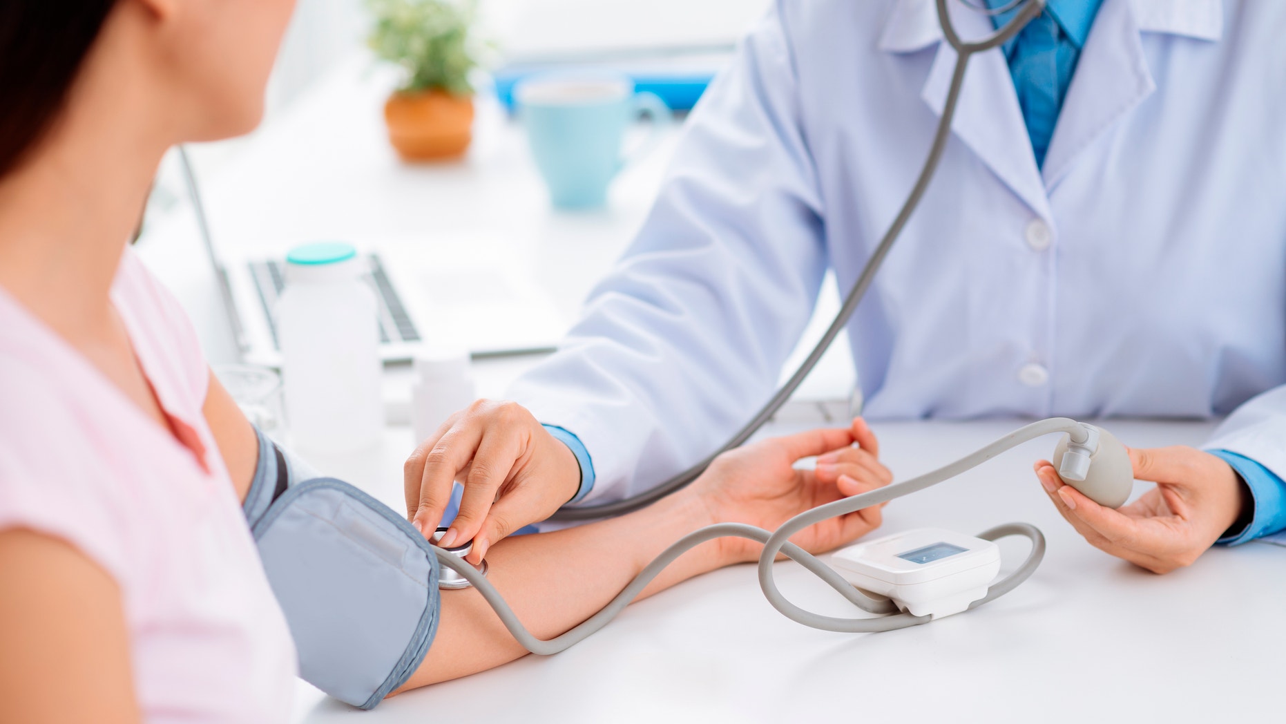 Doctor checking blood pressure of the patient, selective focus