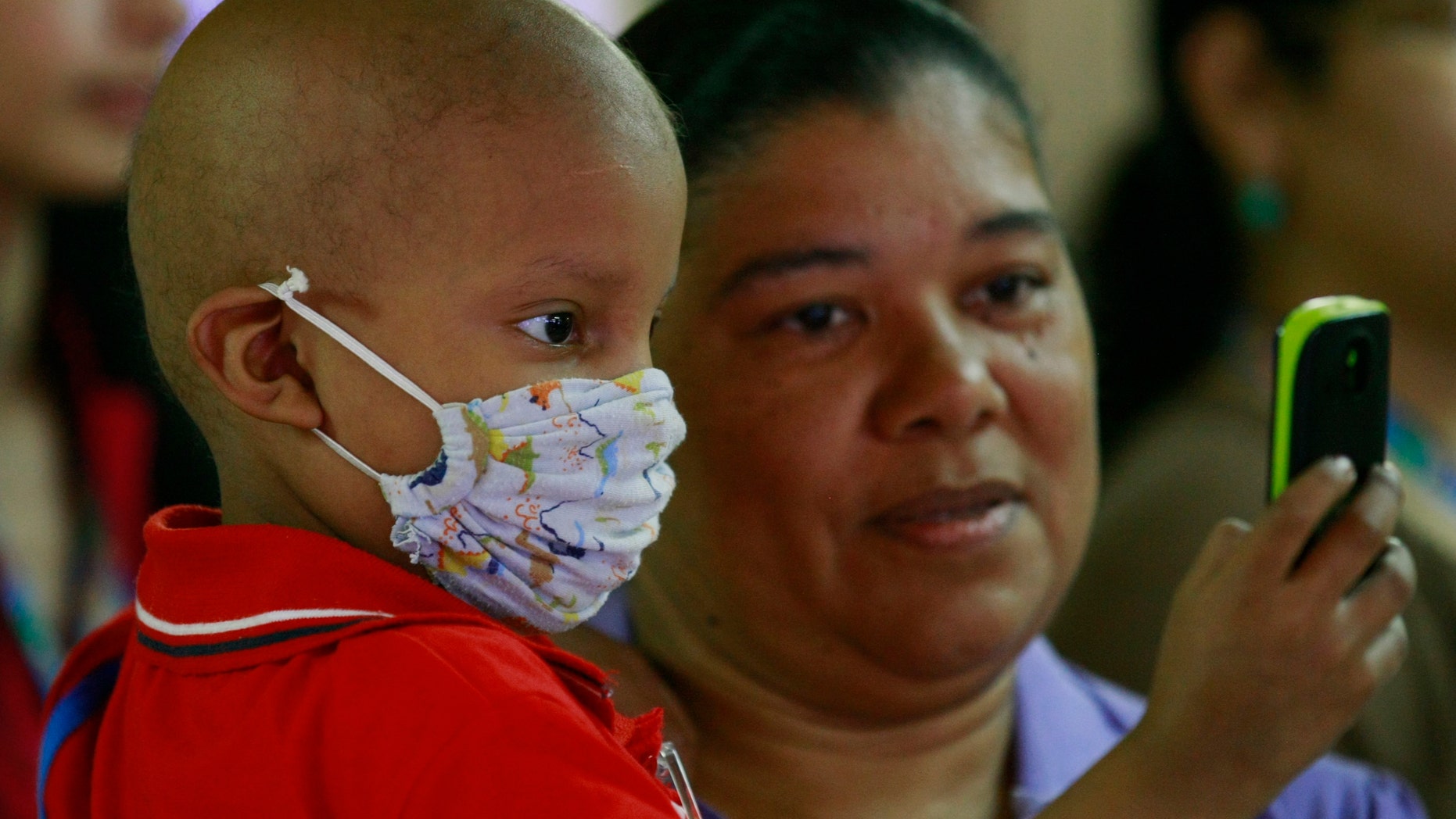 Antonio Ojeda, 3, looks at a cellular phone while receiving chemotherapy treatment at a pediatric hospital.