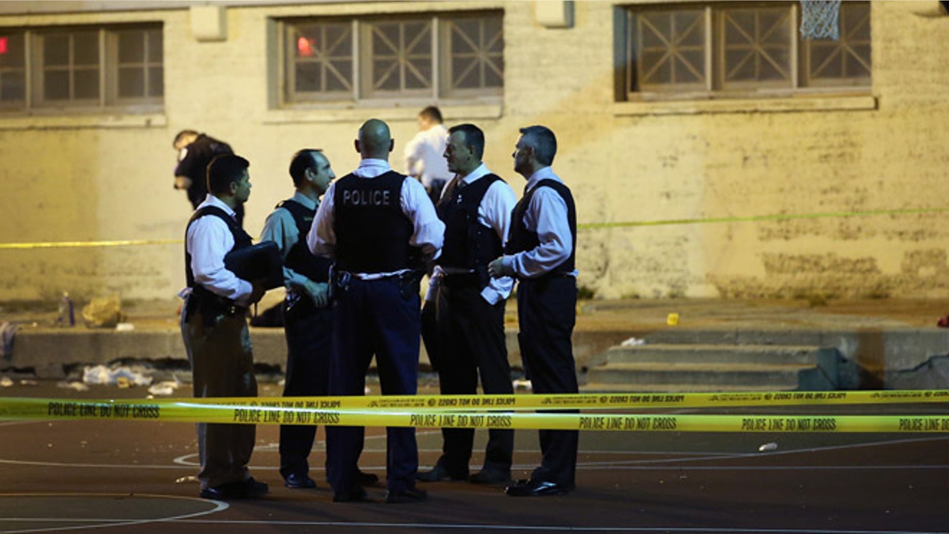 CHICAGO, IL - SEPTEMBER 19: Police investigate the scene in Cornell Square Park on the Southside where 11 people including a three-year-old child were shot on September 19, 2013 in Chicago, Illinois. Eighteen people were reported shot in the city, including one fatally, in less than a four-hour period on Thursday evening. (Photo by Scott Olson/Getty Images)